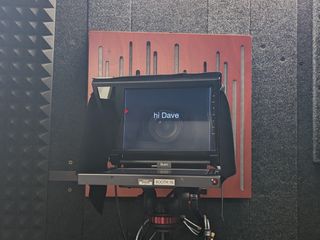 Teleprompter in front of camera lens with 'hi Dave' displayed.